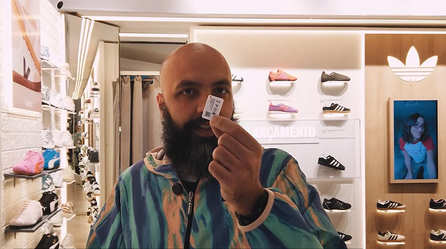 موظف يحمل علامة منارة m4 في متجر بيع بالتجزئة حديث لشركة Adidas يعرض الأحذية