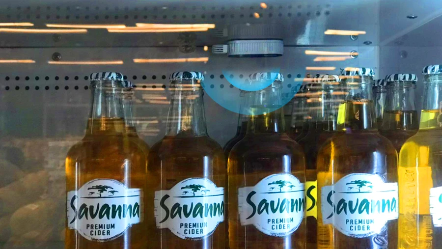 Botellas de sidra de sabana en pantalla refrigerada con sensores de temperatura y humedad de Moko H4 para monitoreo automatizado de frescura en el supermercado ghanés