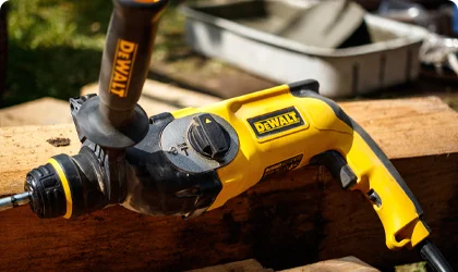 Close-up of DeWalt power tools (drill and planer) on wooden surface