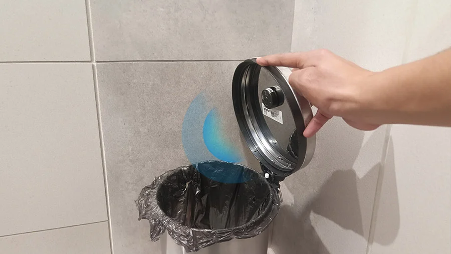 ToF sensor mounted on trash bin lid detecting fill level in an office restroom