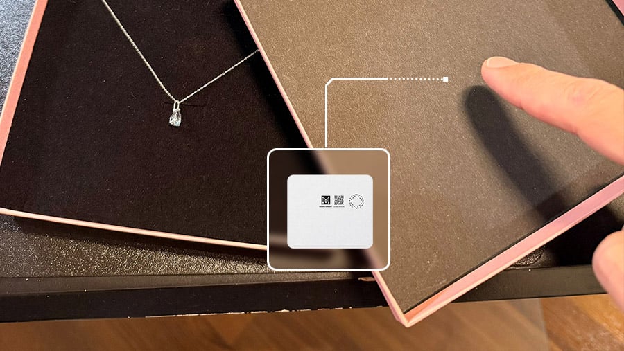 UT1 ultra-thin BLE paper asset tag placed under a luxury jewelry box lid for subtle tracking.
