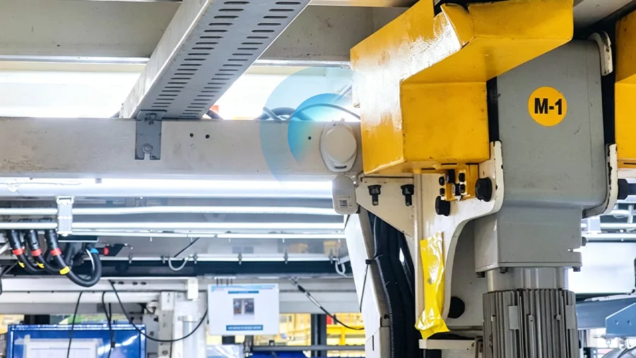 Industrial Bluetooth location beacon attached to machinery on a manufacturing assembly line