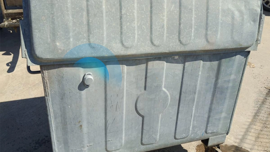 M2 BLE asset tracking tag mounts on garbage bin for real-time monitoring.