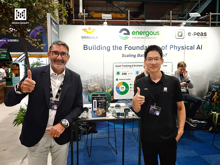 Two men pose for photo in front of MOKO SMART and Dracula Technologies booth.