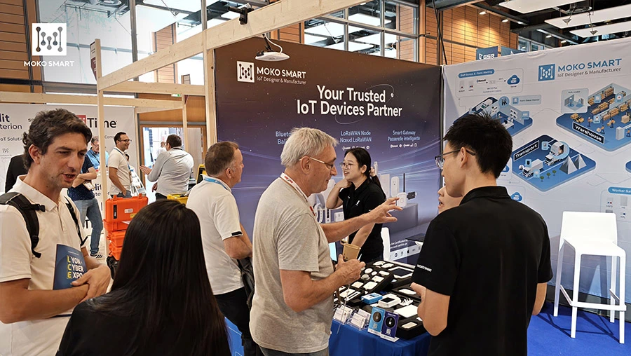 MOKO SMART staff explain IoT devices to visitors at booth.